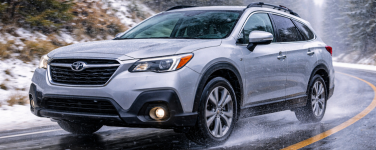 Subaru driving on wet and lightly snowy road with all-season tires for year-round performance.