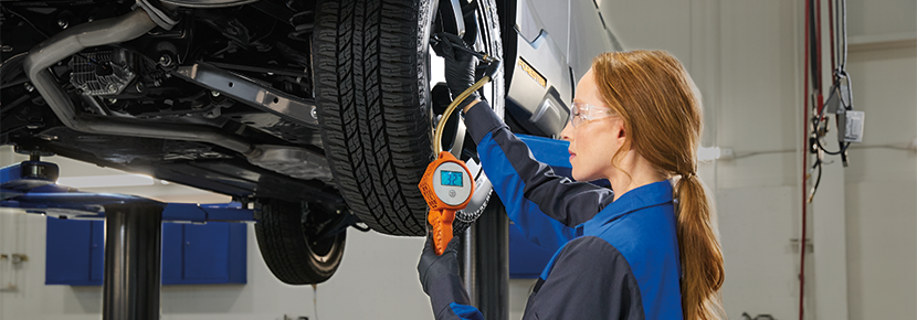 A Subaru technician checking tire pressure. | Subaru City of Milwaukee in Milwaukee WI